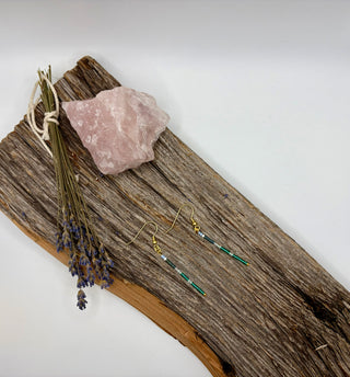 Seed bead earrings on rustic wood surface.