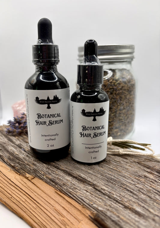 Two bottles of Botanical Hair Serum on a wooden surface with a blurred background