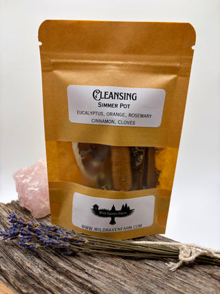 Package of 'Cleansing Simmer Pot' with ingredients listed on a wooden surface.