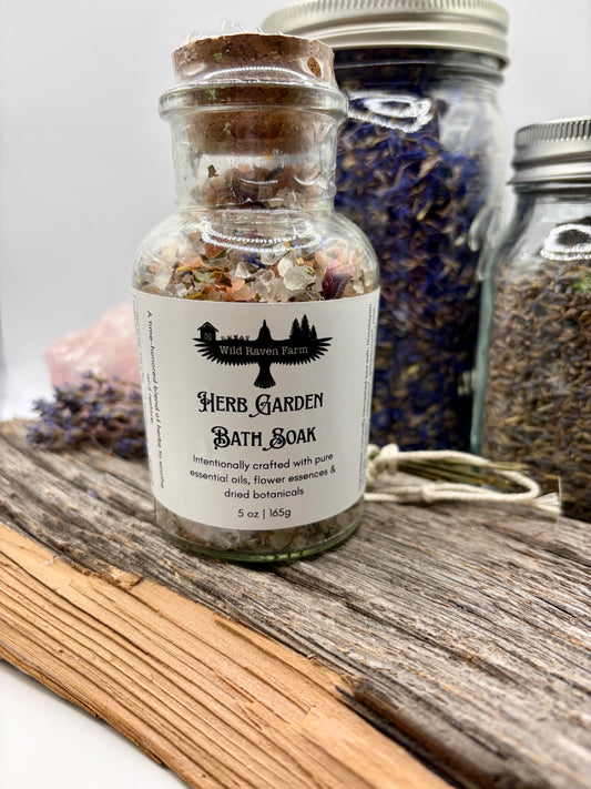 Herb Garden Bath Soak in a glass jar with a cork lid on a wooden surface.