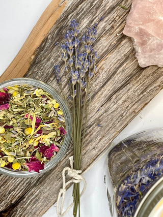 Herbal mix in a jar with dried lavender on a wooden board