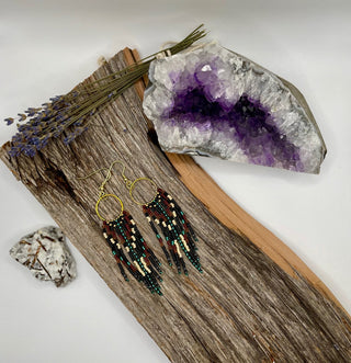 Earrings on a wooden surface with a crystal and lavender flowers