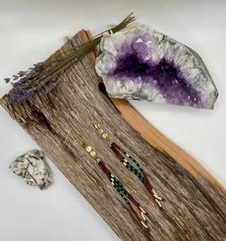 Beaded earrings on a wooden surface with an amethyst crystal and lavender flowers.