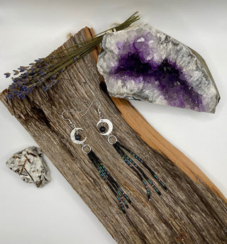 Earrings with beads on a wooden surface with a geode and lavender.