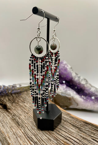 Beaded earrings on a stand with a natural stone background