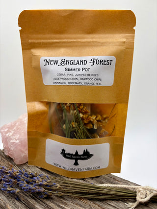 Packaged New England Forest simmer pot with dried herbs on a wooden surface.