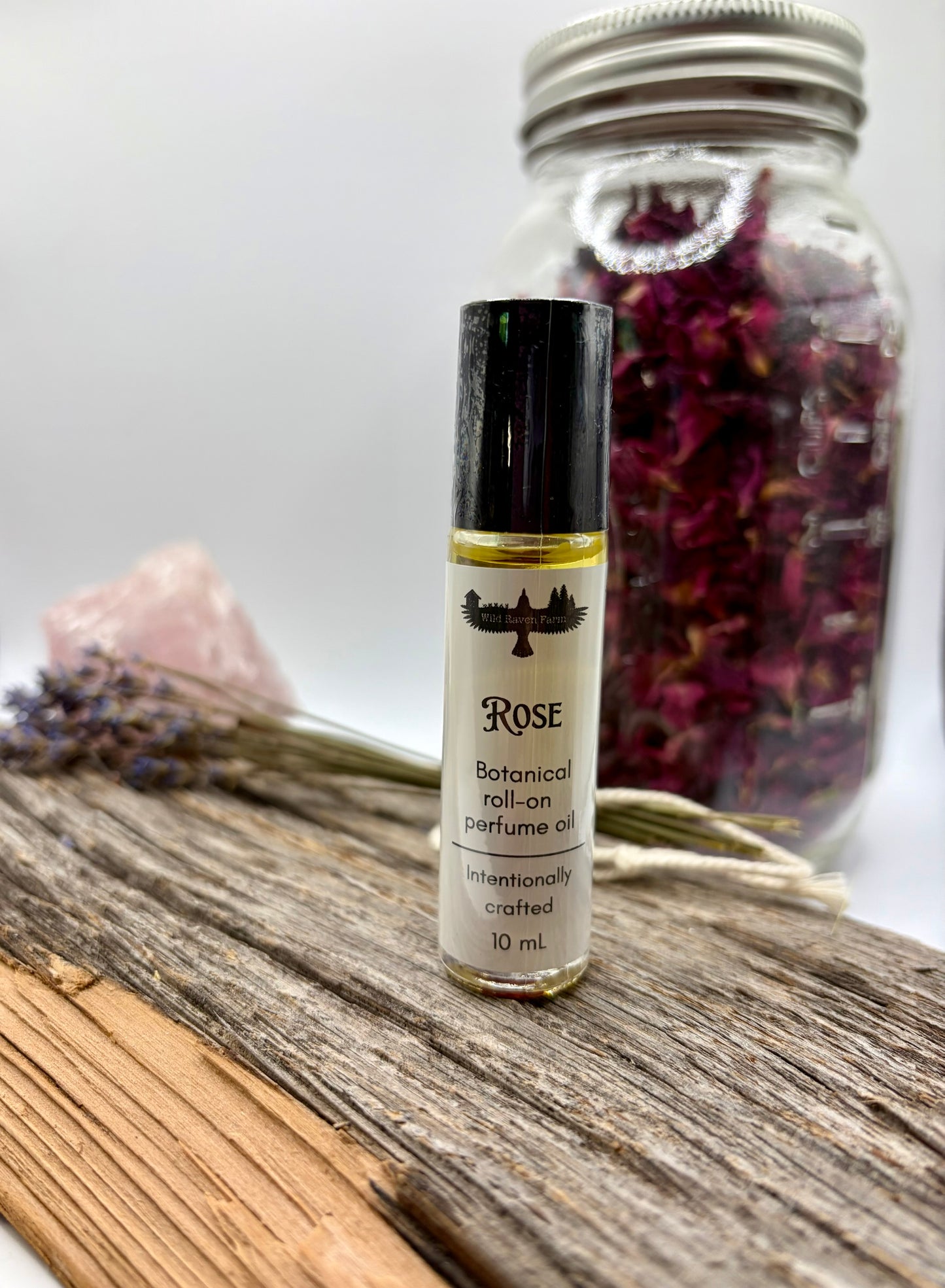 Roll-on perfume bottle labeled 'Rose' on a wooden surface with a blurred background