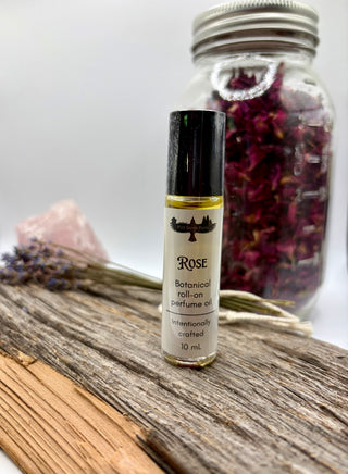 Roll-on perfume bottle labeled 'Rose' on a wooden surface with a blurred background