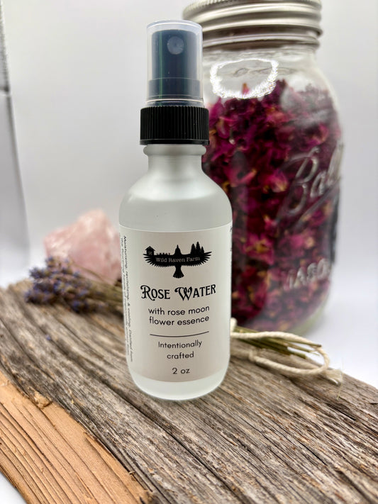 Rose water spray bottle with a jar of dried flowers on a wooden surface