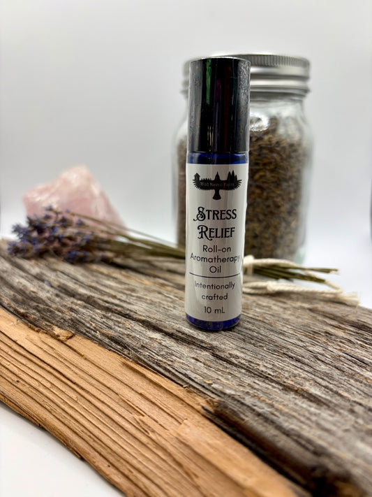 Roll-on aromatherapy oil bottle labeled 'Stress Relief' on a wooden surface with lavender and a jar in the background.