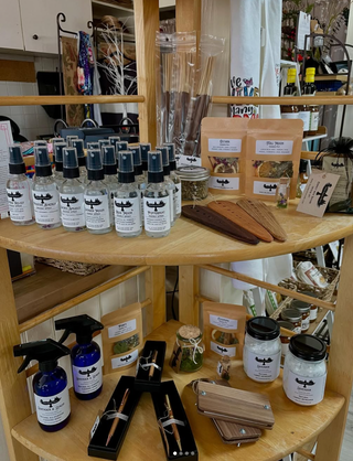Wooden shelf with various products including bottles, jars, and wooden items in a store setting.