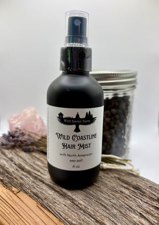Bottle of Wild Coastline Hair Mist on a wooden surface with lavender and sea salt.