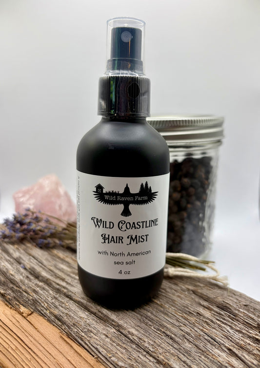 Bottle of Wild Coastline Hair Mist on a wooden surface with lavender and sea salt.