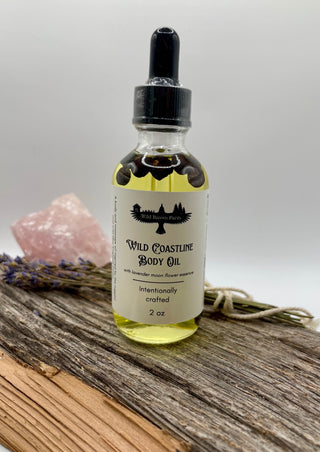 Bottle of Wild Coastline Body Oil on a wooden surface with a gray background