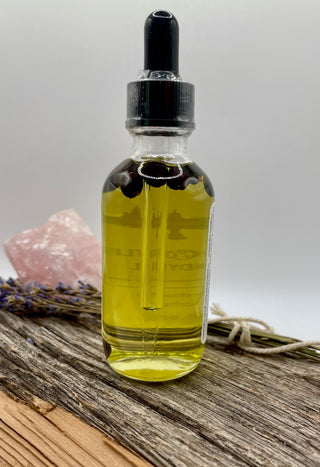 Bottle of oil on a wooden surface with juniper berries