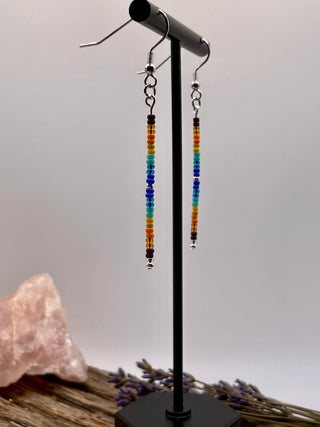 Beaded earrings on a black stand with a neutral background