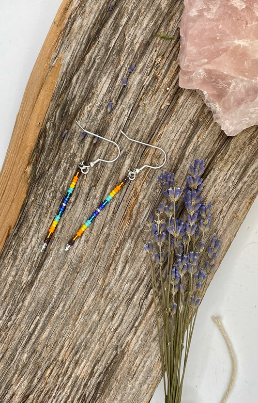 Beaded earrings on a wooden surface with lavender flowers